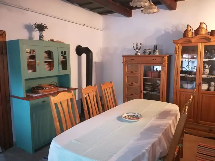 A konyha hosszú asztala székekkel, mögötte a festett szekrény